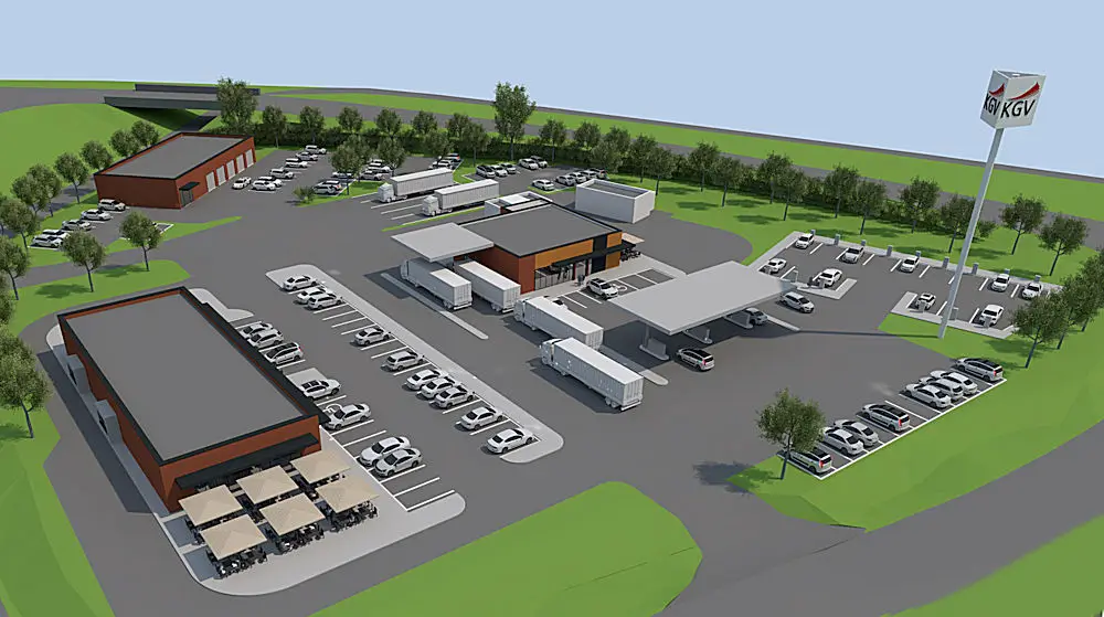 Auf der Visualisierung ist eine Raststätte abgebildet. Die drei Teilbereiche bestehend aus Tankstelle für PKW und LKW, Gastronomie und Werkstattgebäude werden von sehr vielen Parkplätzen für PKW ergänzt. Die Zufahrt zur Raststätte befindet sich im Bild rechts unten. Rechts neben der Zufahrt befindet sich die Tankstelle, links die Gastronomie mit Terrasse. Im Bild hinten links befindet sich die Werkstatt mit fünf großen Hallentoren. Zwischen der Gastronomie und der Werkstatt befindet sich die Ausfahrt. Das Raststätten-Gelände ist von großen Bäumen umsäumt. Sehr viele Parkplätze sind mit weißen PKW belegt. Im rechten Bildrand ist ein Pylon zu erkennen mit dem Logo KGV. Die Fläche auf dem Rasthof ist asphaltiert und ohne Fahrbahnmarkierungen.