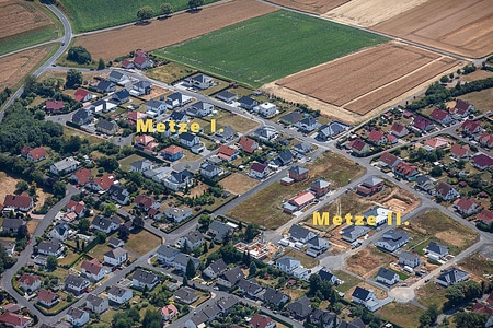 Neubaugebiete Metze I und Metze II in 34613 Schwalmstadt-Treysa Auf dieser Luftaufnahme sind zwei Neubaugebiete zu sehen. Die Bauplätze sind fast alle mit Einfamilienhäusern bebaut. Über Stichstraßen erreicht man die einzelnen Grundstücke. Angrenzend an die Baugebiete erkennt man im hinteren Bereich Felder und Wiesen.